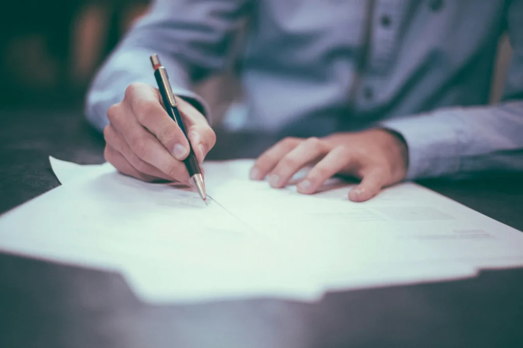 Person writing on financial paperwork